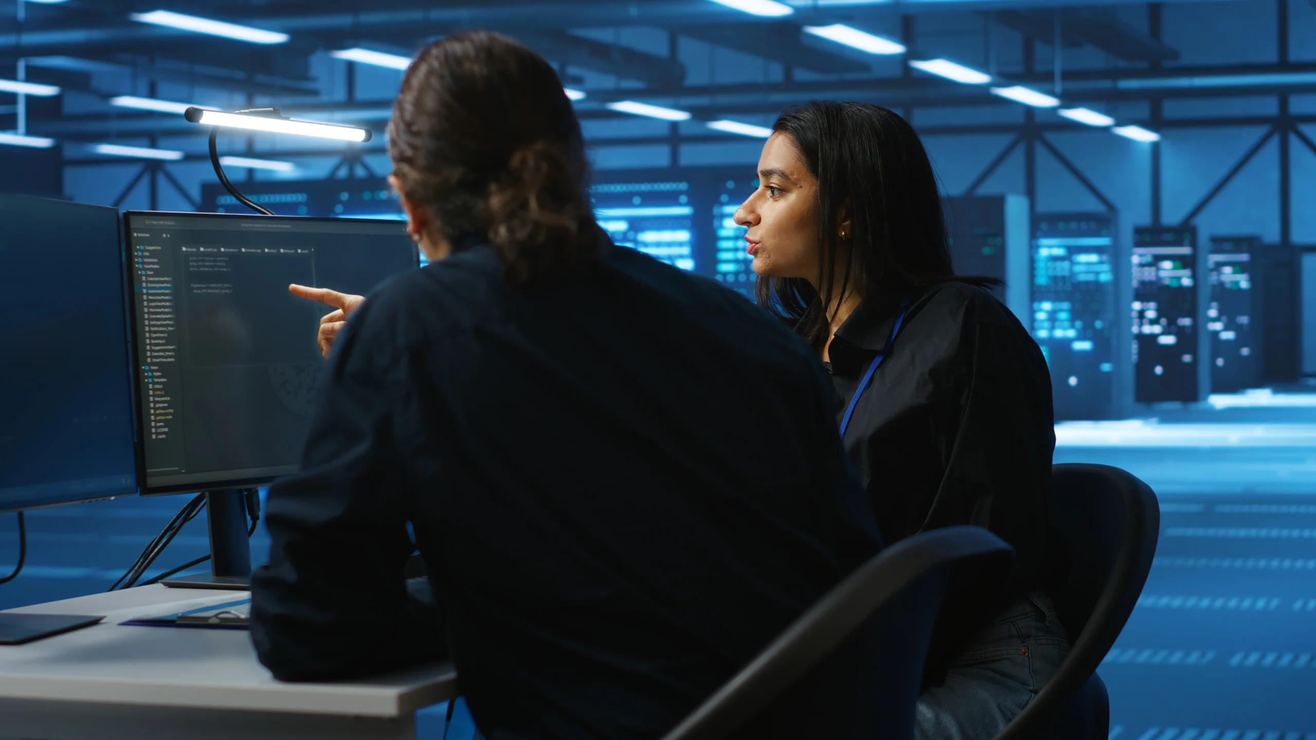Experto aconsejando a una alumna en el ordenador